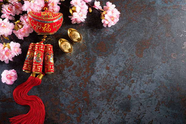 Decorações de festival de ano novo chinês pow ou pacote vermelho, lingotes de laranja e ouro ou caroço dourado em um fundo de textura de pedra preta. Personagens chineses FU significa sorte boa sorte, riqueza, fluxo de dinheiro
. - Foto, Imagem