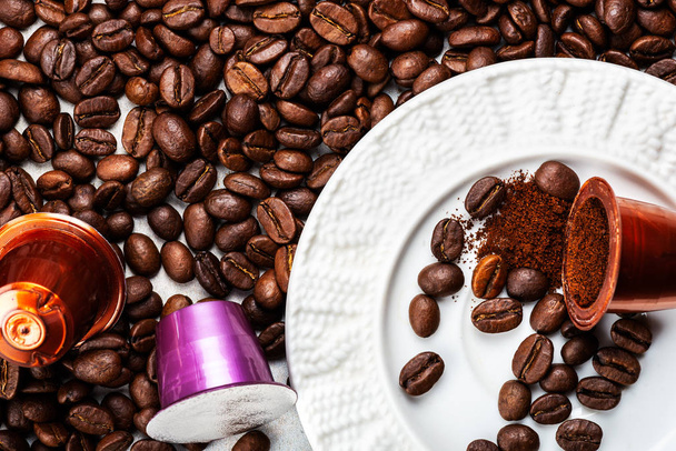 Κάψουλες ή κάψουλες καφέ Espresso και κόκκοι καφέ σε γκρι φόντο - Φωτογραφία, εικόνα