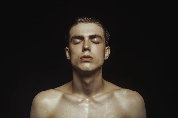 Handsome wet sport sexy stripped guy portrait with waterdrops and smoke on isolated black background - 写真・画像