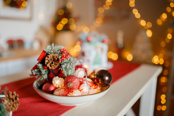 Beautiful holiday decorated kitchen with Christmas tree and bright lights , holiday glasses on the main plan, blur background - Fotoğraf, Görsel