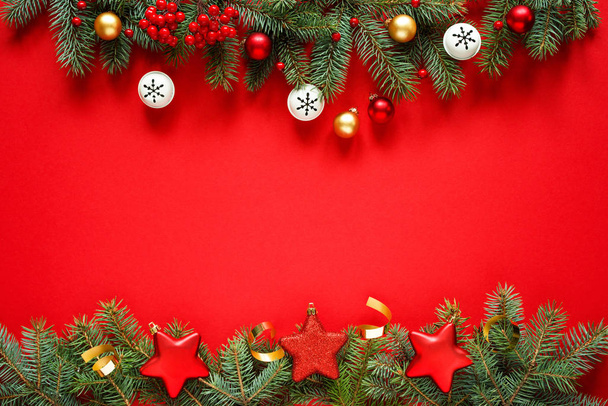 Fondos de invierno de Navidad, tarjeta de Navidad. Las ramas de flores y las decoraciones de vacaciones en un fondo rojo, la vista superior con espacio para texto.. - Foto, Imagen