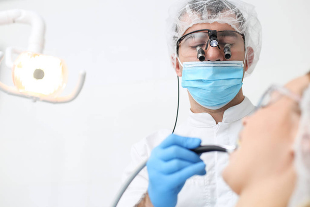 Professional dentist drilling his patients teeths with dental drill - Foto, Bild