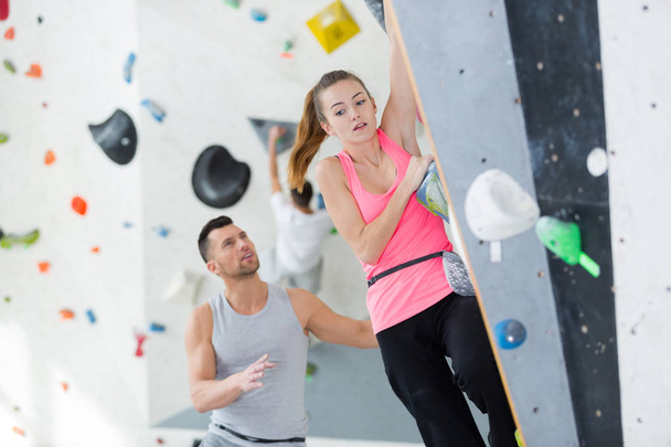 nervous lady on indoor climbing wall - Foto, afbeelding