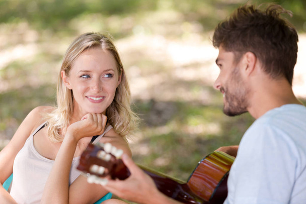 man playing guitar to girlfriend - Valokuva, kuva