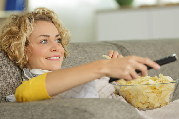 girl eating chips and watching tv - Фото, зображення
