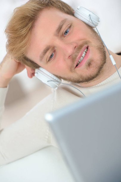 close view of young man relaxing with laptop and headphones - Фото, зображення