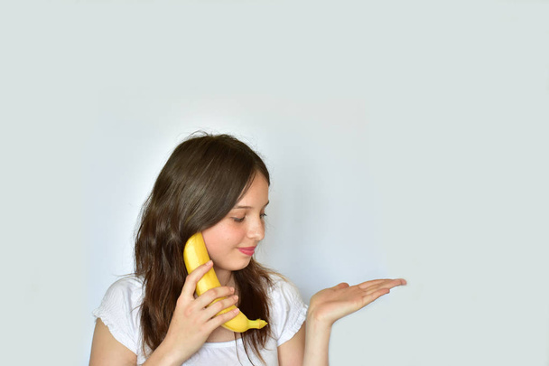 κορίτσι με μπανάνα σε λευκό φόντο - Φωτογραφία, εικόνα