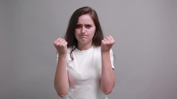 Poważna kobieta w białej koszuli macha pięściami, trzymając ręce na pasku - Materiał filmowy, wideo