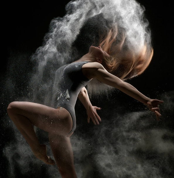 Girl dancing in a cloud of white dust studio portrait - Foto, Imagen