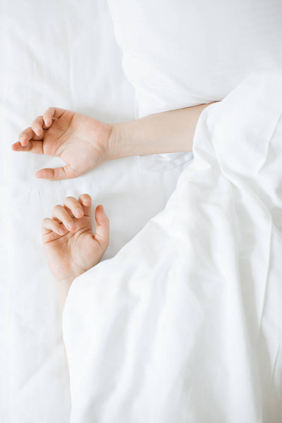 Cropped female hands in white bed - Fotó, kép