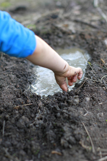 Anonymous child arms and hands playing with mud and water - Foto, Imagen