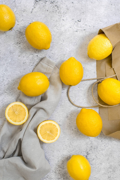 lemons with clothes and bag on gray background  - Фото, зображення