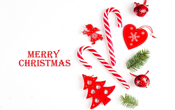 Christmas composition with message merry christmas, with fir tree branches and holiday ornament on white background. Flat lay, top view. - Foto, afbeelding