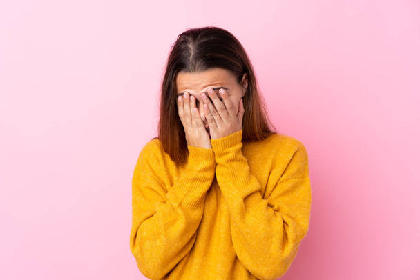Teenager dívka se žlutým svetrem přes izolované růžové pozadí s unaveným a nemocným výrazem - Fotografie, Obrázek
