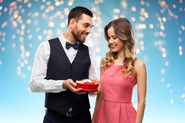 happy couple with chocolate box in shape of heart - Zdjęcie, obraz