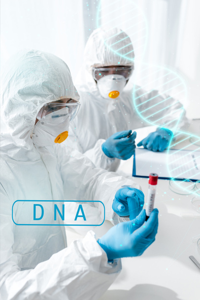 scientifique pointant du doigt et faisant un test ADN et son collègue afro-américain regardant l'illustration ADN
  - Photo, image