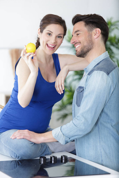happy pregnant woman is holding a lemon - Foto, imagen