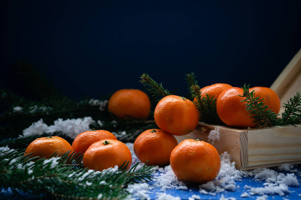 Tangerines in a wooden box handmade in the snow.  - 写真・画像
