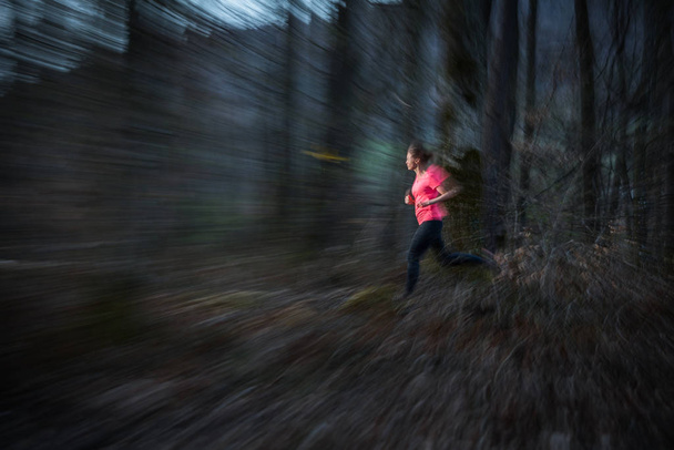 Young woman running outdoors in a forest - Foto, Bild