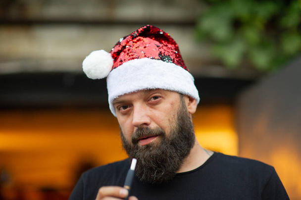 Papai Noel andando na rua da cidade. Homem com barba na rua no verão em um chapéu de Papai Noel
. - Foto, Imagem