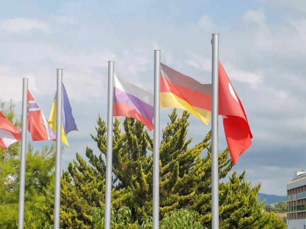 flagi różnych krajów na maszcie flagowym przeciwko błękitnemu niebu w indyku - Zdjęcie, obraz