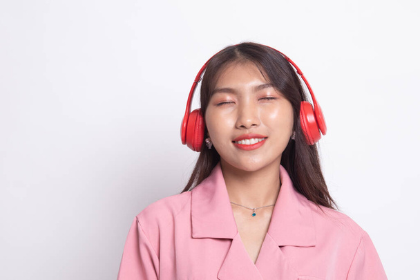 Pretty asian girl listening music with her headphones. - Zdjęcie, obraz