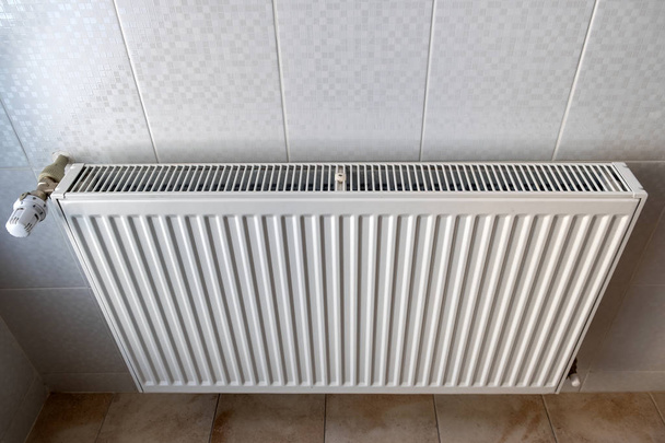 Witte metalen verwarming radiator gemonteerd op een muur in de ruimte interieur. - Foto, afbeelding