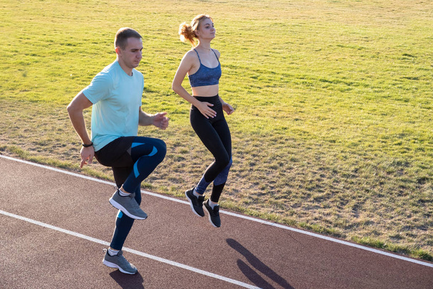 Jeune couple de sportifs en forme garçon et fille courir tout en faisant e
 - Photo, image