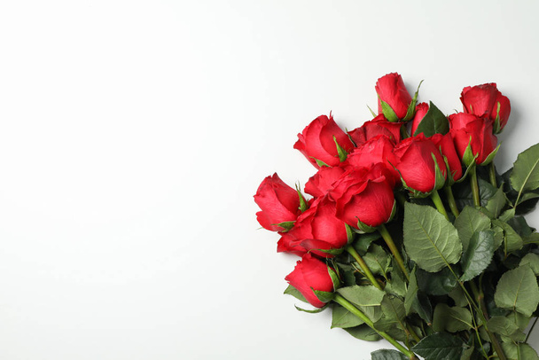 Boeket rode rozen op witte achtergrond, ruimte voor tekst - Foto, afbeelding