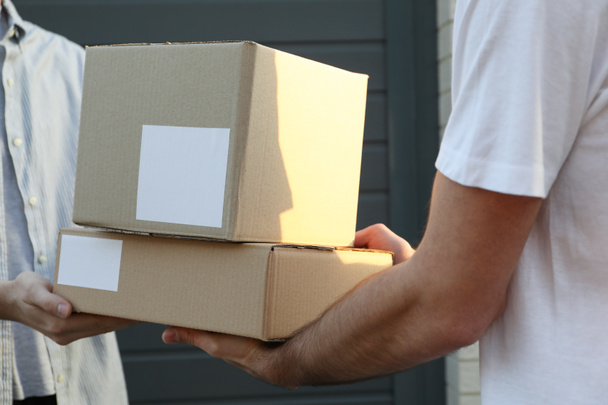 Ο άνθρωπος λαμβάνει κουτιά από τον διανομέα εξωτερική, κενό χώρο - Φωτογραφία, εικόνα