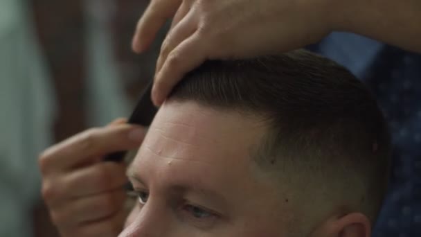 Close up of barbers hands combing mans hair in slow motion.  - Metraje, vídeo