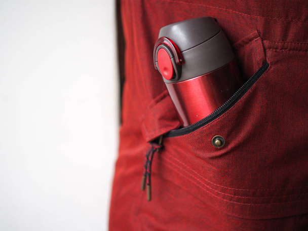 κοντινό πλάνο της κούπας θερμός στην πλαϊνή τσέπη του σακακιού - Φωτογραφία, εικόνα