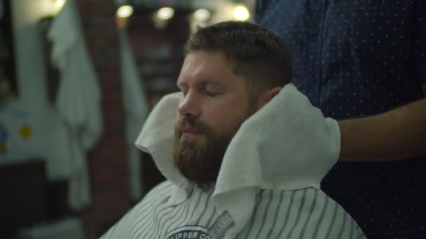 Barbers hands drying mans hair with white towel in barbershop in slow motion.  - Video, Çekim