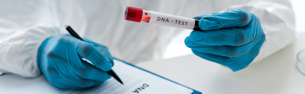 panoráma felvétel a tudós írás és gazdaság kémcső betűző DNS teszt  - Fotó, kép