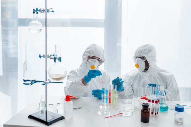 multicultural scientists in protective suits doing dna test in lab  - Foto, afbeelding