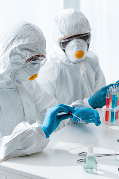 scientifiques multiculturels en combinaisons de protection faisant des tests ADN en laboratoire
  - Photo, image