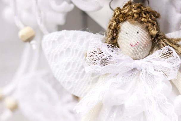 Şirin melek tekstil bebeği kıvırcık saçlı, beyaz dantelli kazandı. - Fotoğraf, Görsel