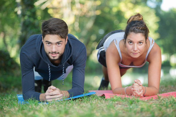 young couple training in acro yoga in the park - Foto, Imagen