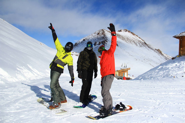  Tres snowboarders en una montaña
 - Foto, Imagen
