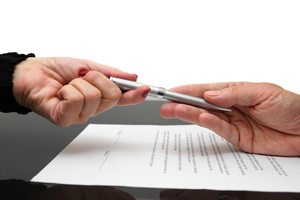 Businessman giving pen to businesswoman for signing contract or - Photo, image