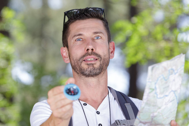 man orienteering in woodlands with map and compass - Foto, Bild