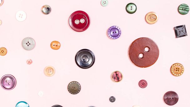 top view of various buttons arranged on pink - Foto, Imagem