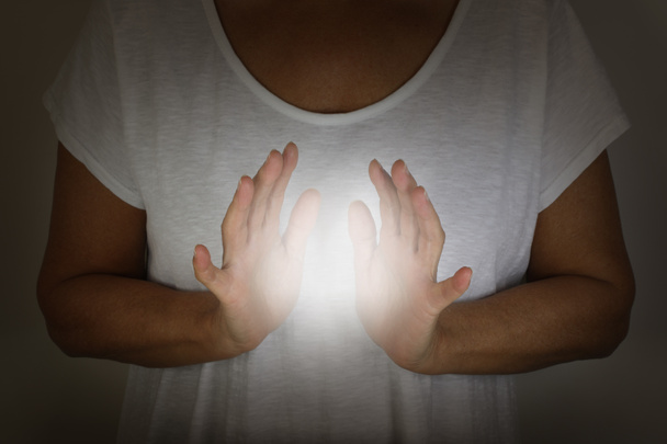 Curandeiro demonstrando como sentir o eletromagnético humano com as mãos - conceito - mulher em um top branco com as mãos em torno de uma bola branca de energia
  - Foto, Imagem