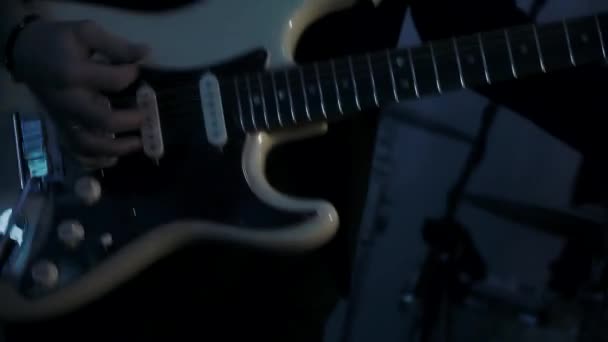A man plays on a white electric guitar in a club - Felvétel, videó