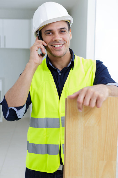 portrait of construction worker discussing floor plans inside - Φωτογραφία, εικόνα