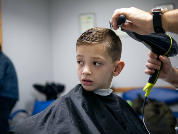 mladý chlapec si nechává udělat vlasy - Fotografie, Obrázek