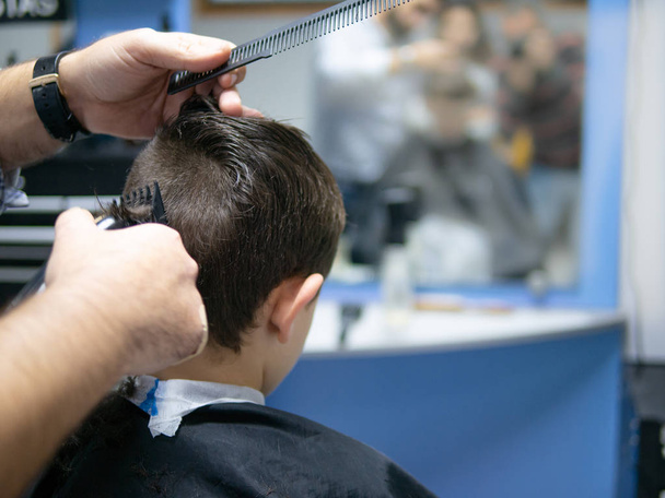 Rücken eines Jungen, der sich die Haare schneiden lässt - Foto, Bild