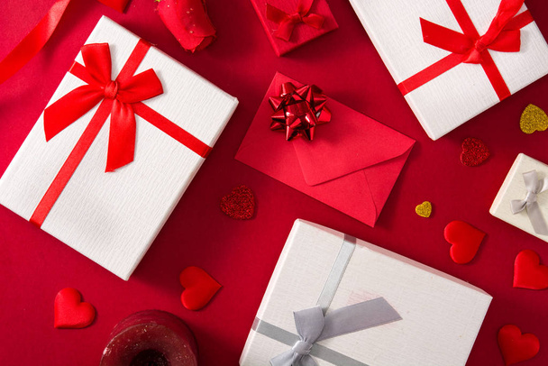Caixas de presente, envelope de papel vermelho e corações vermelhos no fundo vermelho
 - Foto, Imagem