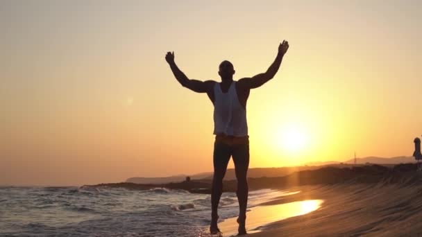Een man cross fit training op een strand doen ster springt springen boeren. - Video