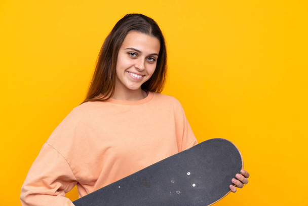 Young skater girl over isolated yellow background - Fotoğraf, Görsel
